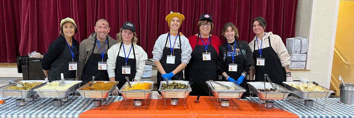 Group of volunteers serving food at the thanksgiving feast event