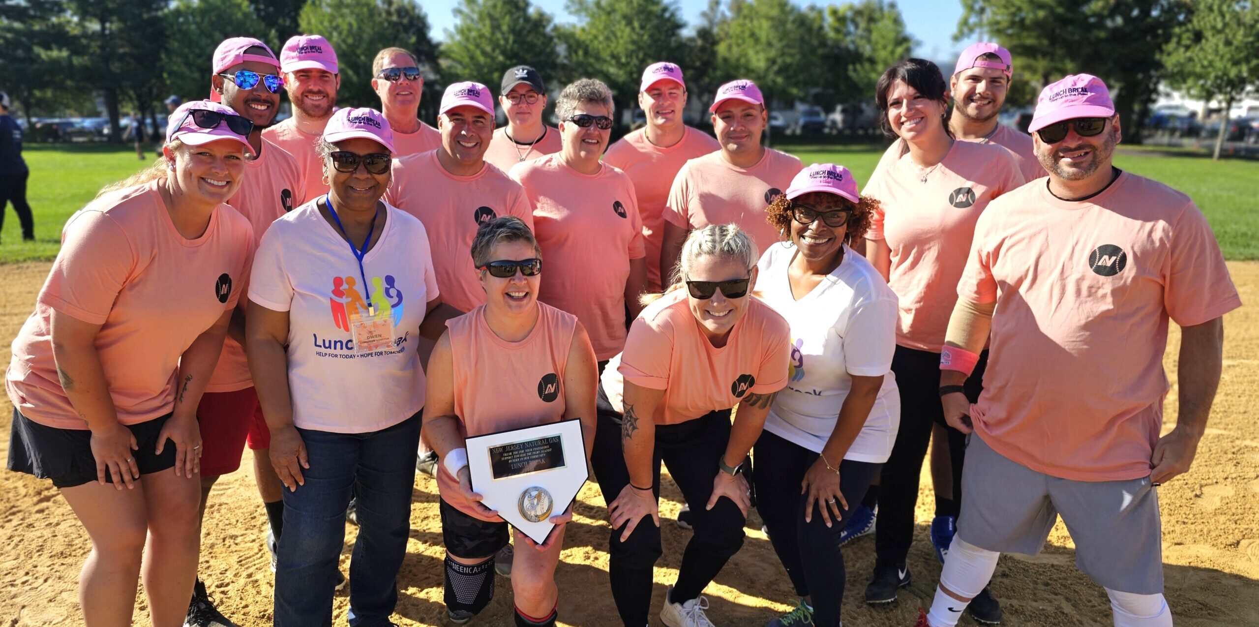 Lunch Break team holding a softball trophy on the field