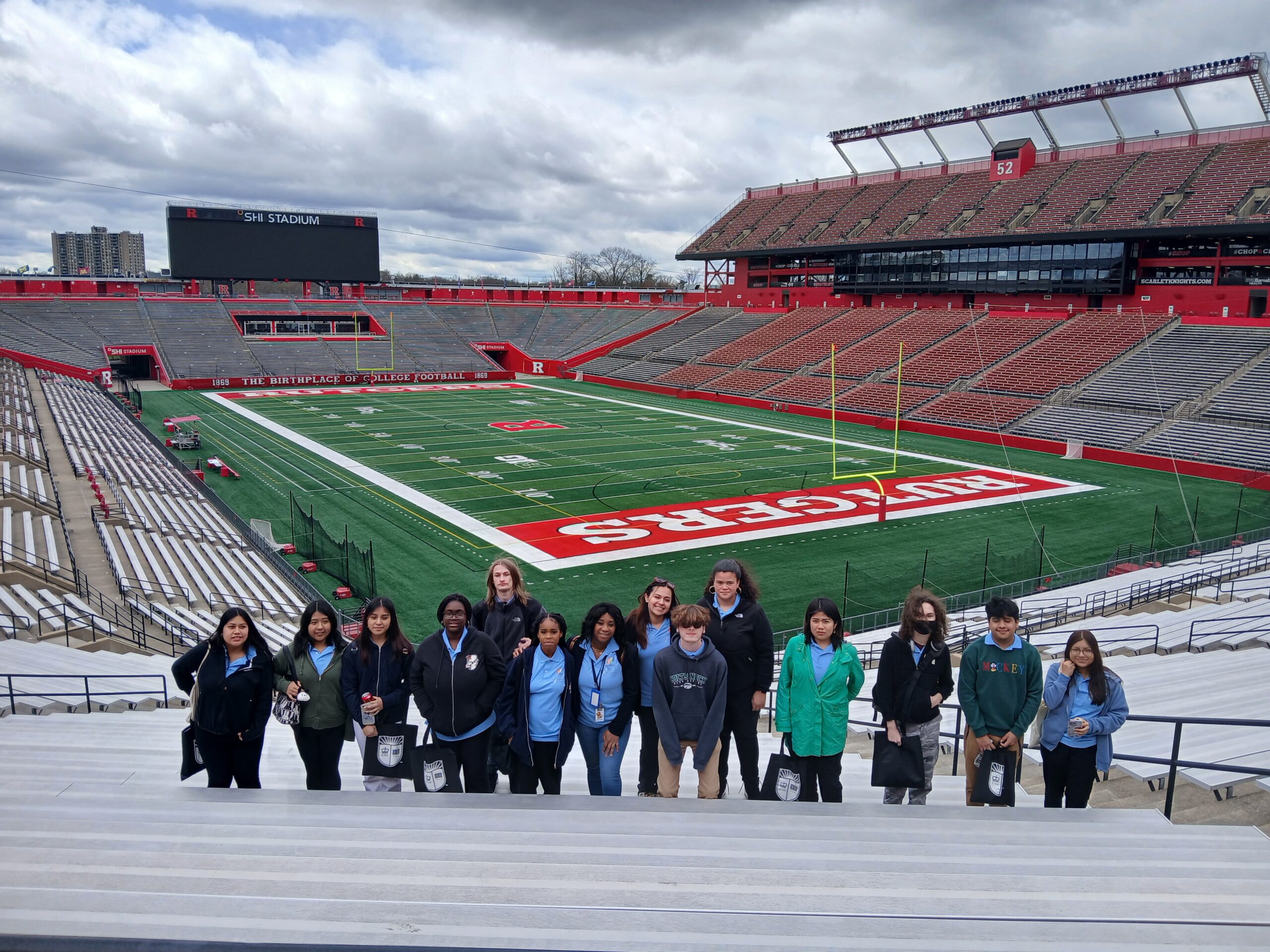 A group of people standing in the bleachers of the Rutgers football stadium