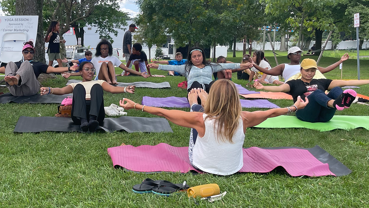 People taking an outdoor Lunch Break sponsored yoga class