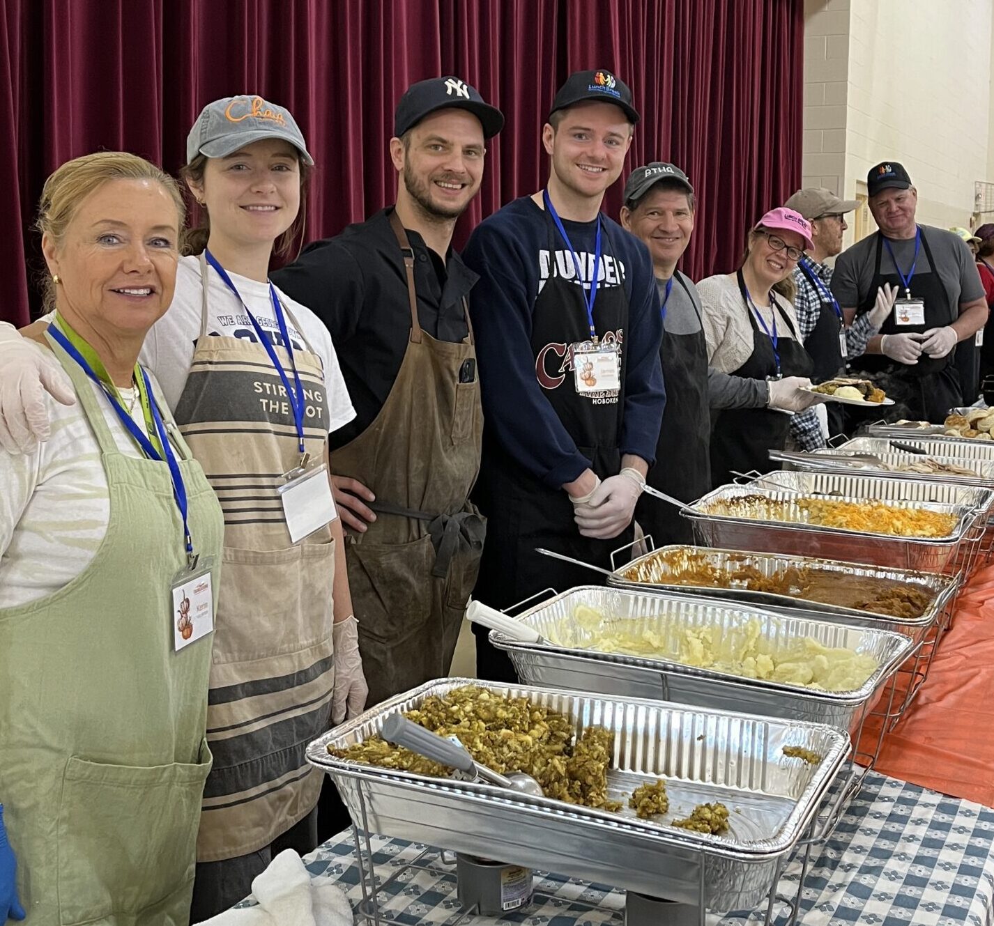 Group of volunteers serving food from the buffet
