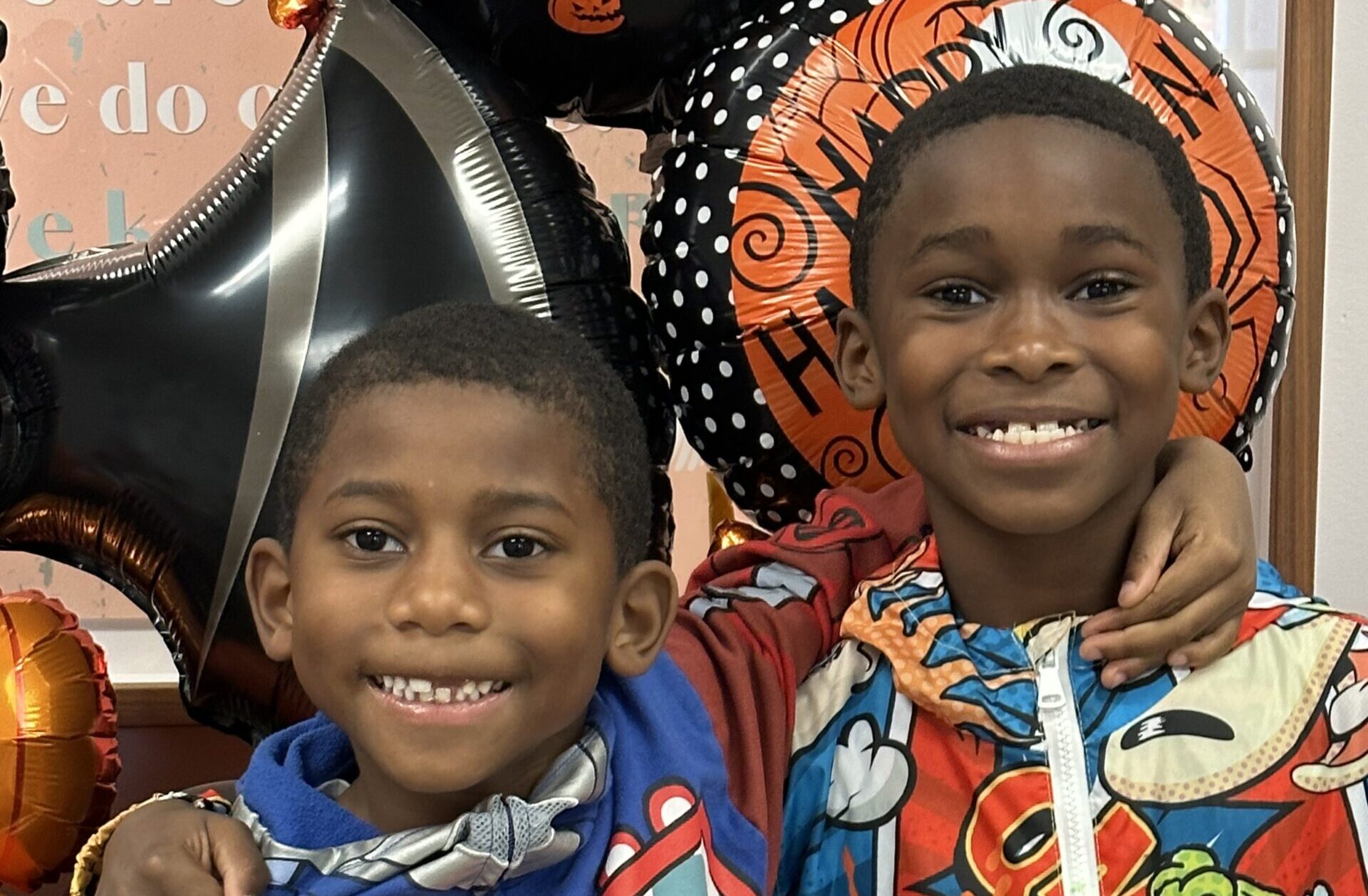 Two children dressed up for halloween smiling at the camera