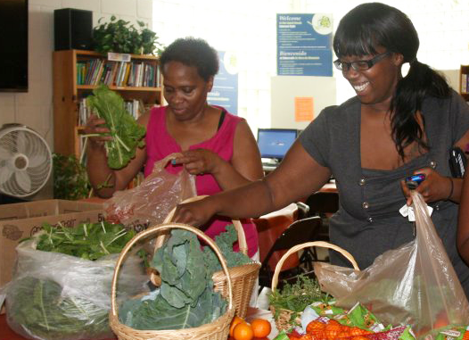 Two women packing bags of food