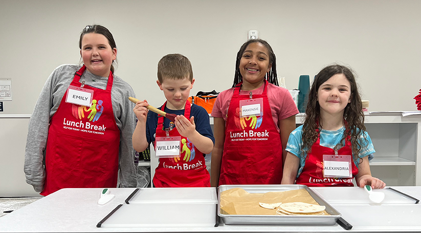 A group of kids in aprons for the kids cooking class
